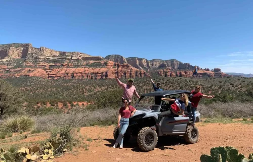 Group of ATV Renters posing for a photo in front of the red rock landscape