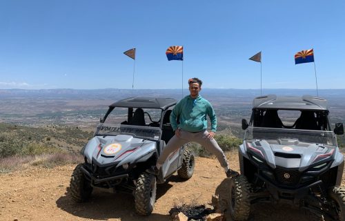 Person posing between two ATV Rentals with view of Verde Valley
